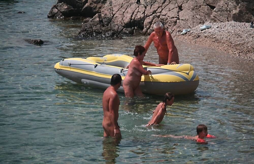Lone Nudist in Yellow Boat photos - Supporters of naturism live in harmony with nature